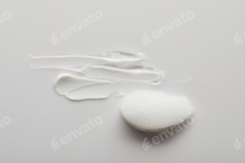 Preview: Top view of gel and cosmetic cream brushstrokes near soap foam on grey background