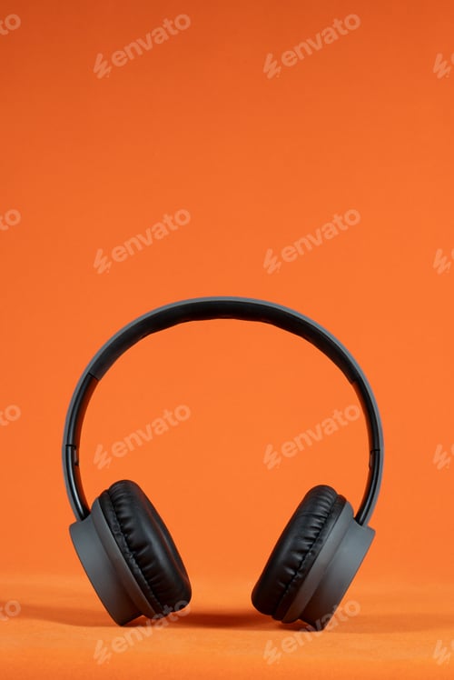 Preview: Black headphones positioned against a bright orange background