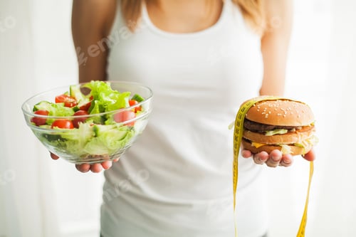 Preview: Woman Measuring Body Weight On Weighing Scale Holding Burger and Salad.