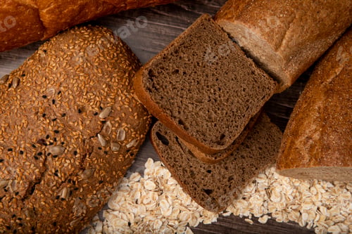 Preview: close-up view of breads as sandwich bread, rye bread, baguette bread with oat-flakes on wooden