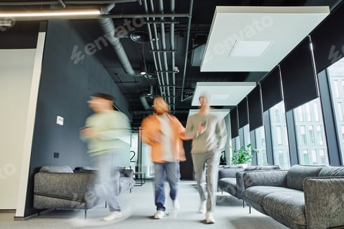 Preview: motion blur of modern entrepreneurs in casual clothes walking along lounge corridor