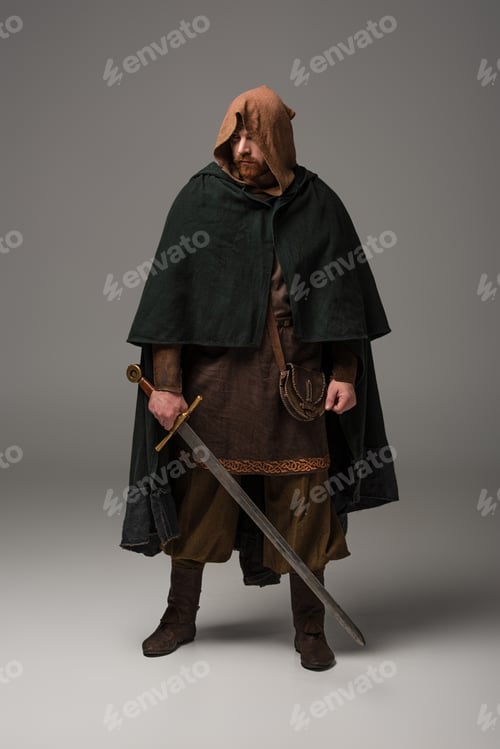 Preview: medieval Scottish redhead knight in mantel with sword on grey background