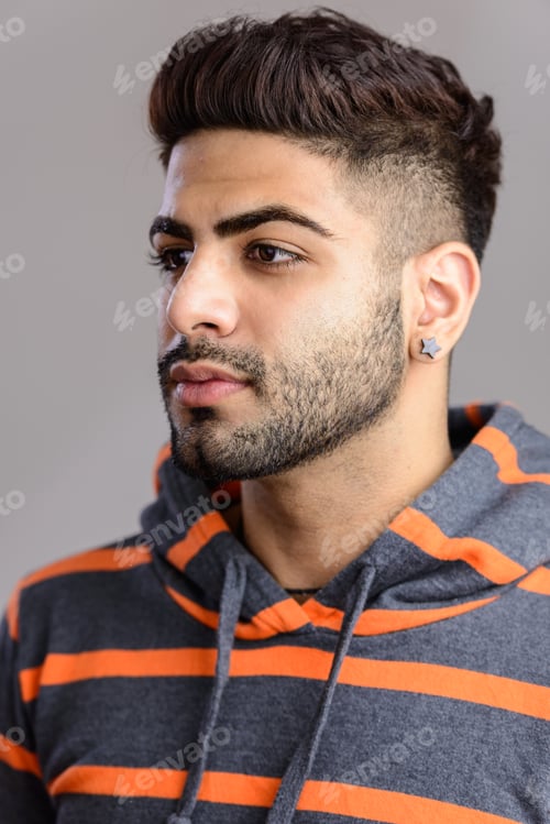 Preview: Portrait shot of young handsome Indian man isolated against gray
