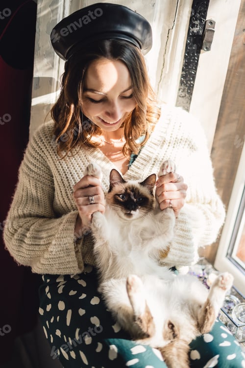 Preview: Pretty woman holding her cat paws stretching