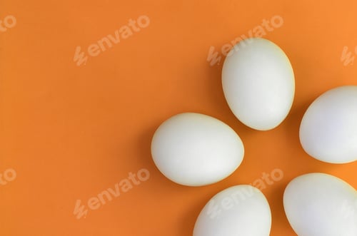 Preview: A few white easter eggs on a bright orange background
