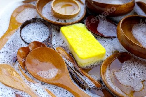 Preview: Wooden kitchenware in water and bubbles of dishwashing liquid