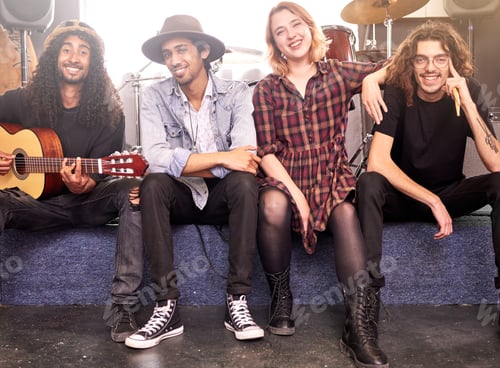 Preview: Were here to entertain you. Full length portrait of a band sitting on stage before their gig.