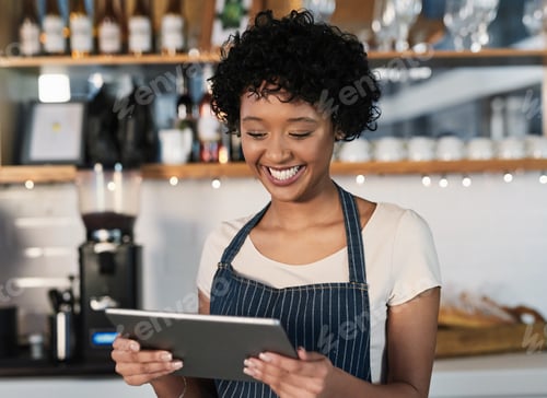 Preview: Shot of a young woman using a digital tablet while working in a cafe