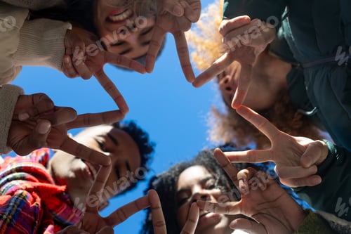 Visualização: Grupo de amigos diversos fazendo forma de estrela com os dedos