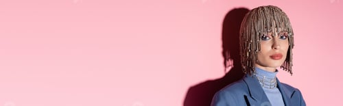 Preview: Pretty woman in luxury headwear looking at camera on pink background, banner