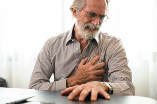 Preview: Senior man holding hand on chest and suffering from heart problem