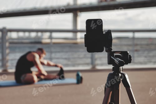 Preview: A young athletic man training fitness outdoors on the city embankment