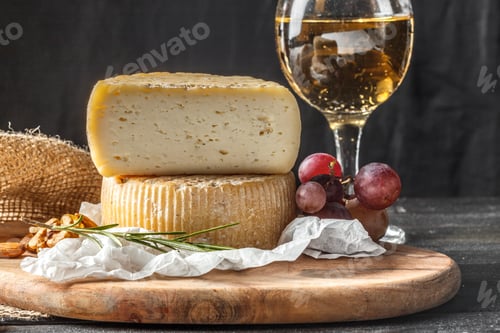 Preview: Delicious cheese and wine pairing on a wooden board with grapes and nuts