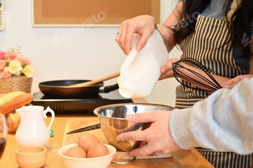 Preview: Cropped shot of young couple having fun cooking together in kitchen.