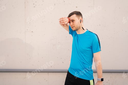 Preview: Sweaty Man Resting After Run Against Concrete Wall