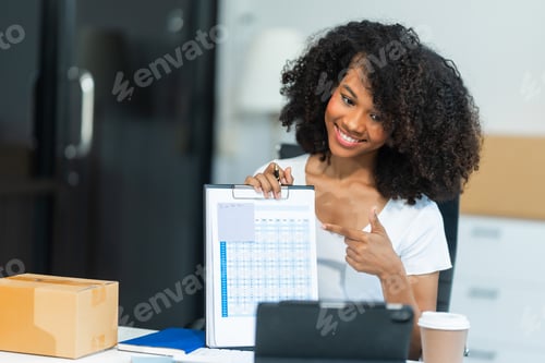 Preview: A young African American woman with afro brown hair works in modern office, management clothing
