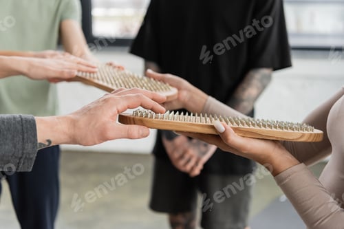 Preview: Cropped view of interracial people holding sadhu board in yoga class