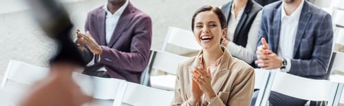 Preview: panoramic shot of attractive businesswoman smiling and clapping during conference