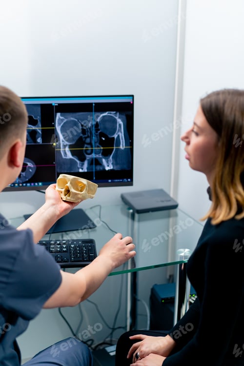 Preview: the radiologist doctor looks at the screen on which the 3D image of the nose scan shows the patient