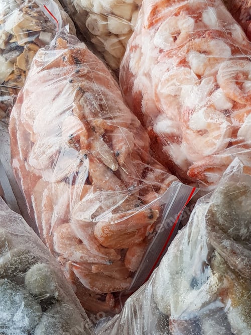 Preview: There are many large plastic bags with frozen raw and boiled shrimp on the counter of the fish