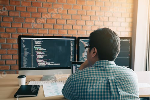 Preview: contemporary website developer writing code for program and looking monitor screen