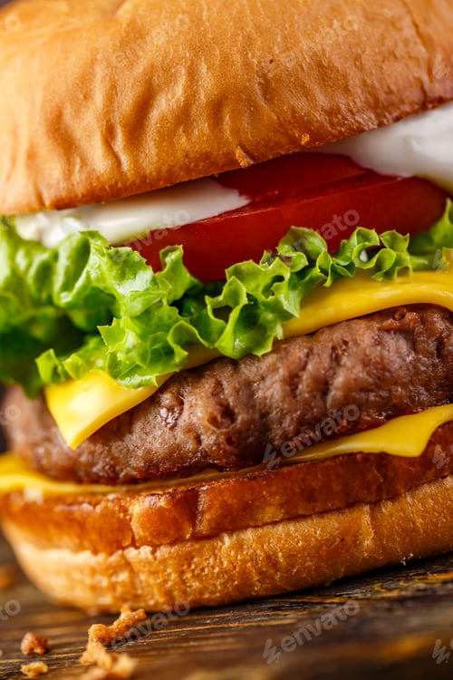 Preview: Close-up of home made tasty burger on wooden table.