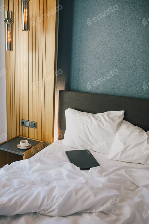 Preview: Bed and white linens in a hotel room.