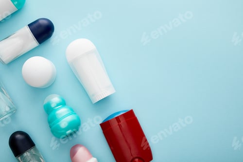 Preview: flat lay with roll on and spray bottles of deodorant on blue background