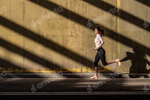 Vista previa: Joven mujer rubia en forma corriendo en la calle