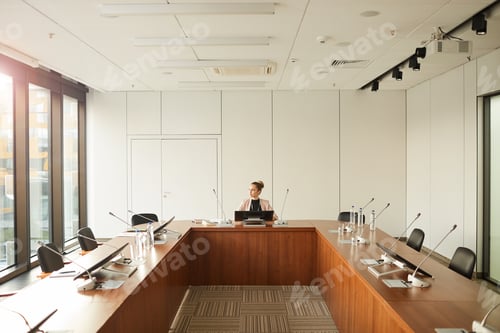 Preview: Female speaker sitting at conference hall