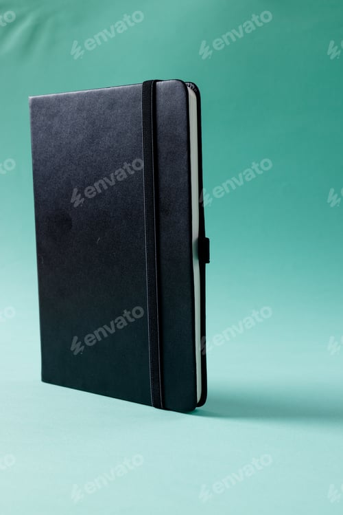 Preview: Close up of black notebook with copy space on green background