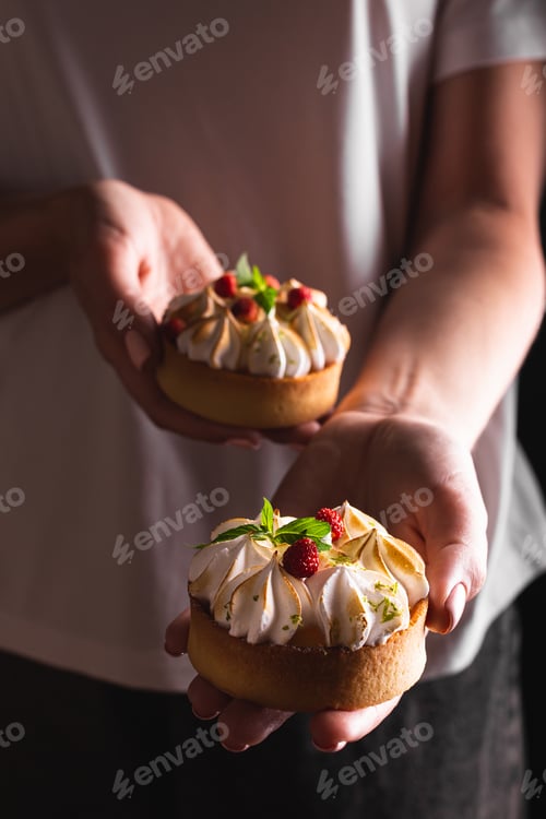 Preview: Young woman holding cakes in her hands