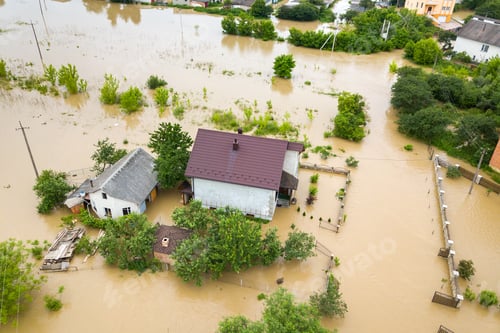 Preview: Aerial view of flooded house with dirty water all around it.