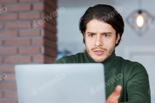 Vista previa: Angry guy freelancer looking at laptop screen