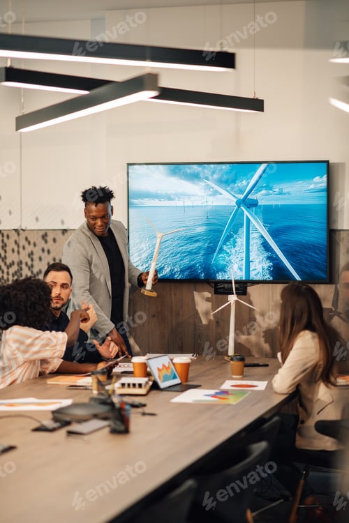 Preview: Interracial ecology engineer with windmill at boardroom on meeting.
