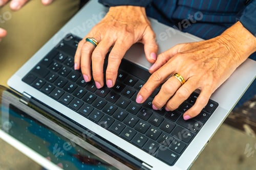 Preview: Senior hands typing on laptop keyboard working outdoors