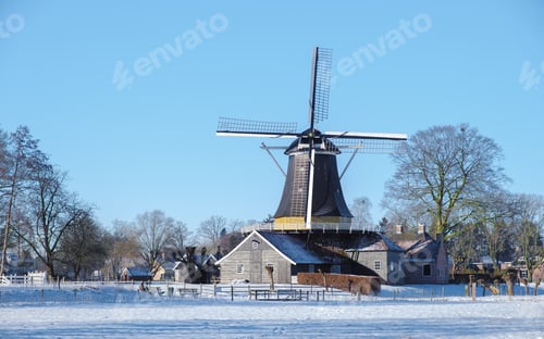 Preview: old historical wooden windmill in the snow in the Netherlands during winter