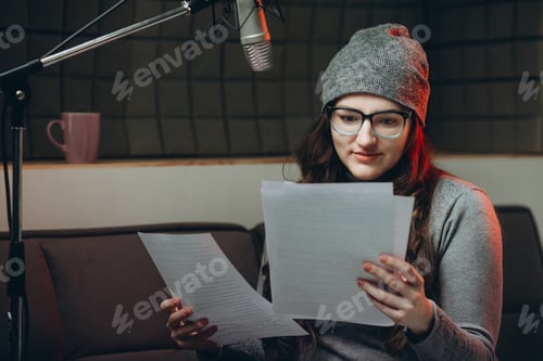 Preview: Woman preparing material before radio show, studio recording.