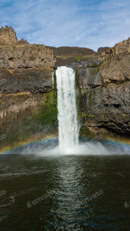 Preview: Vertical shot of the Palouse Falls with the rainbow over it in the United States