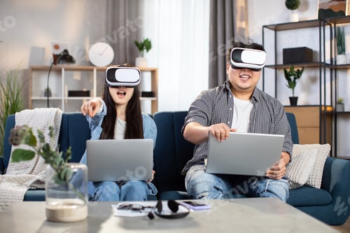 Preview: Asian couple using VR headset and laptop for playing games