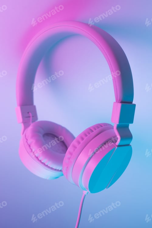 Preview: Retro 90s style photo of white stylish wireless headphone in neon lights. Music concept.