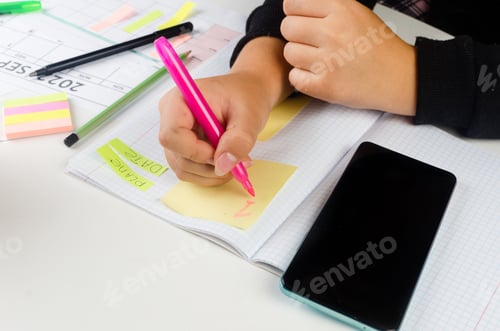 Preview: Girl Hands With Mobile Phone With Calendar Writing And List Of Work In Diary On Desk