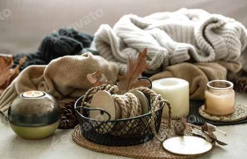 Preview: Still life of home decor details, candles, rope and warm clothes in the background