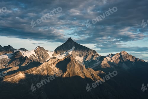 Preview: Rocky mountain with cloudy sky on summit in Swiss Alps