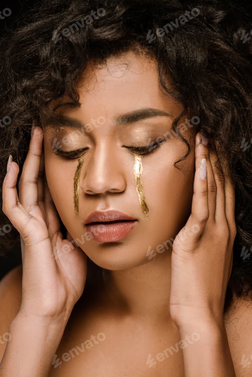 Preview: curly african american woman with golden tears on cheeks and closed eyes