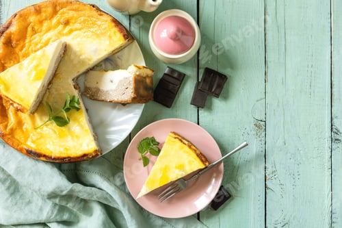 Preview: Delicious lemon cheesecake with tea set for dessert presentation. Top view flat lay background.