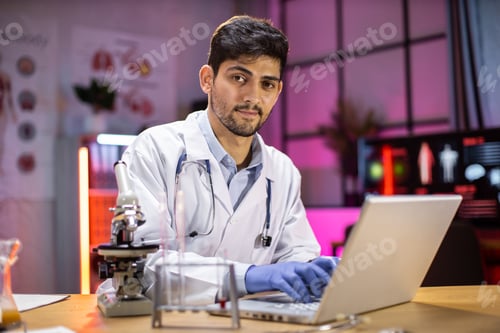 Preview: Medical research laboratory: portrait of a attractive male scientist using digital laptop computer,