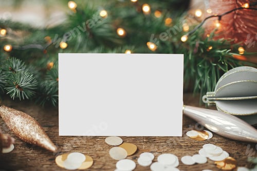 Preview: Empty greeting card, christmas decorations, confetti, lights on rustic wood. Christmas card mock up