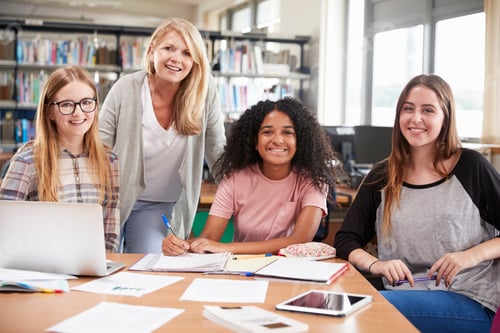 Preview: Woman Teacher Working With Female College Students In Library