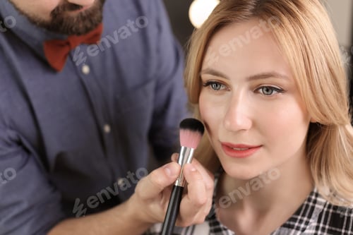 Preview: Professional makeup artist working with client in dressing room